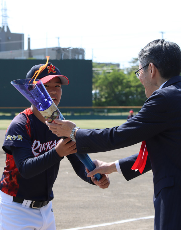 教育長から炬火を受け取るキャプテン